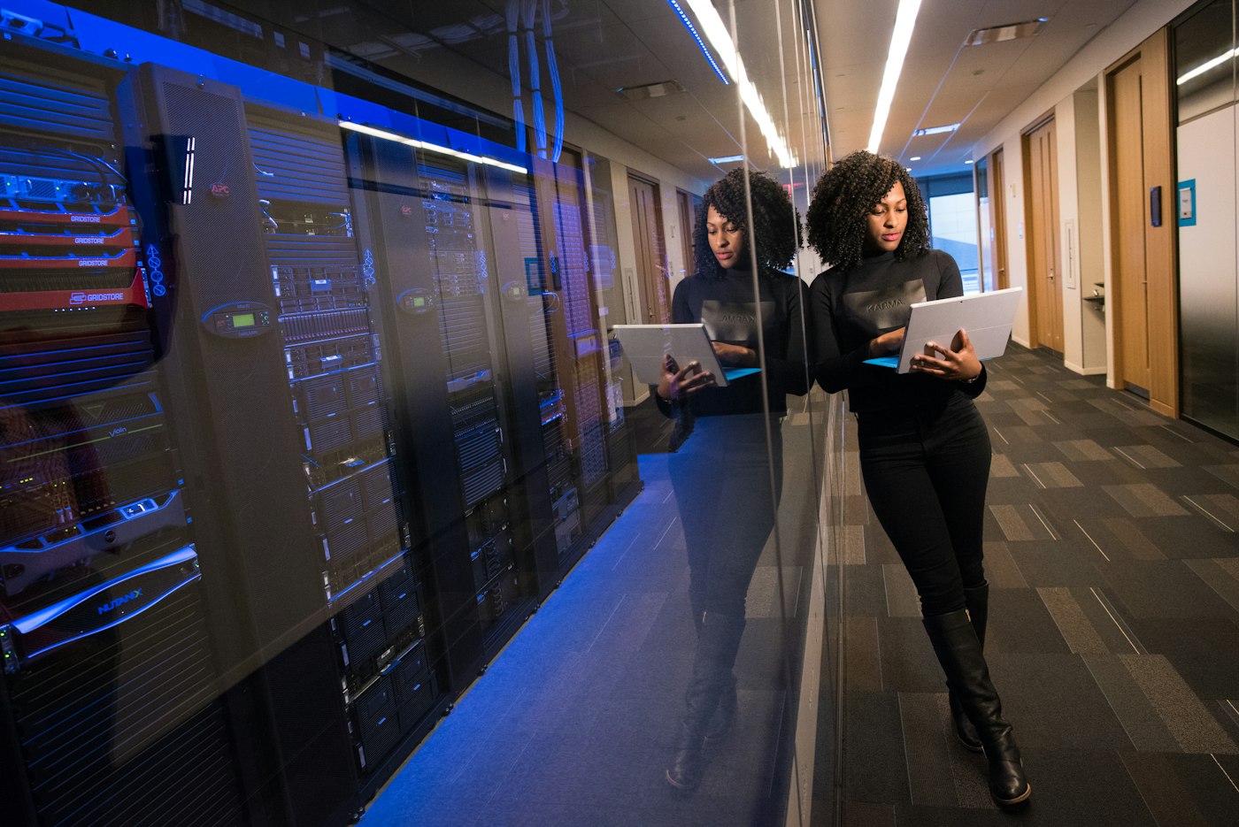 IT professional reviewing systems next to a server rack
